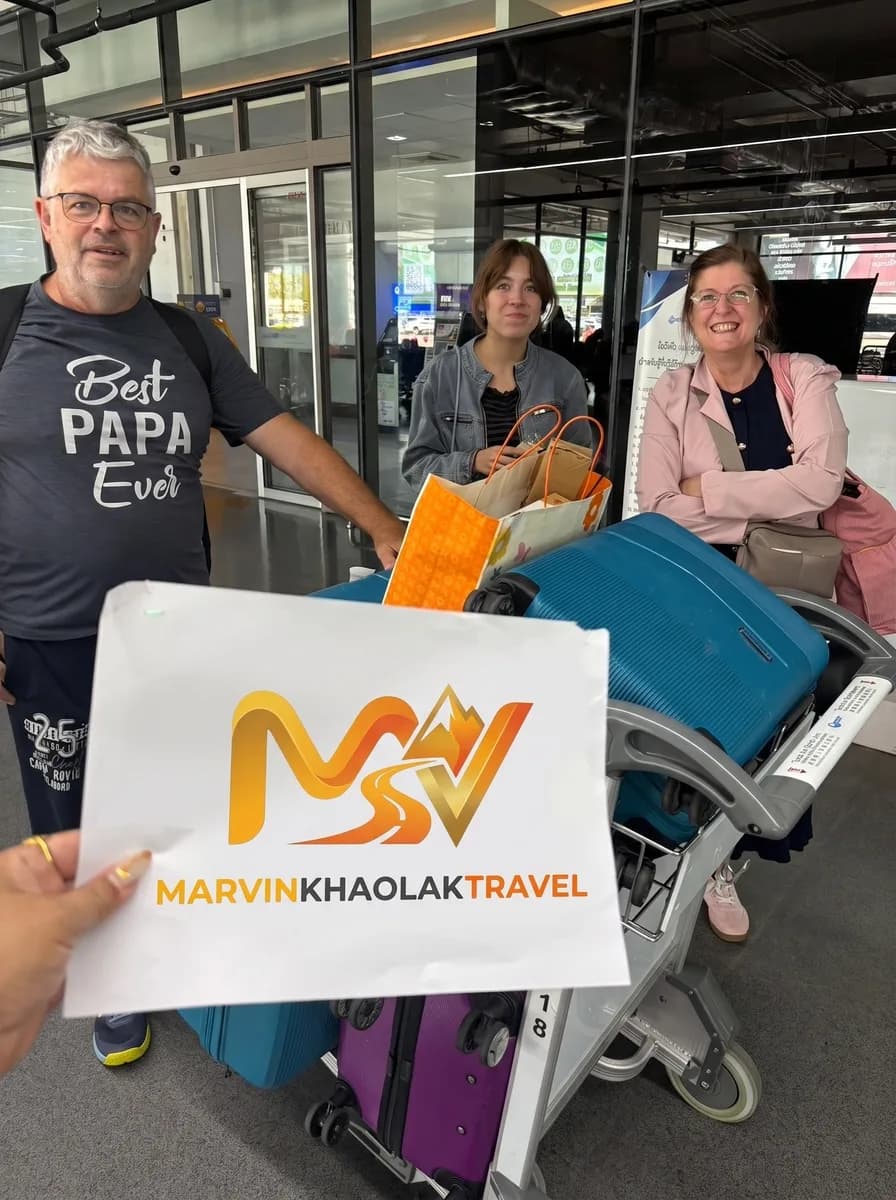 Family with a loaded luggage trolley at Phuket Airport before their transfer to Khao Lak